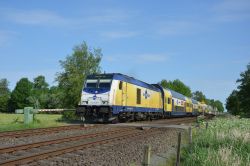 Bombardier Traxx DE Diesellok der Baureihe 246 des Metronom mit Doppelstockzug an einer Anrufschranke bei Wingst an der Strecke Hamburg - Cuxhaven