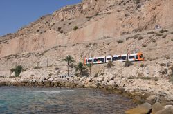 Stadtbahn Alicante fährt an der Steilküste entlang, im Vordergrund das Mittelmeer