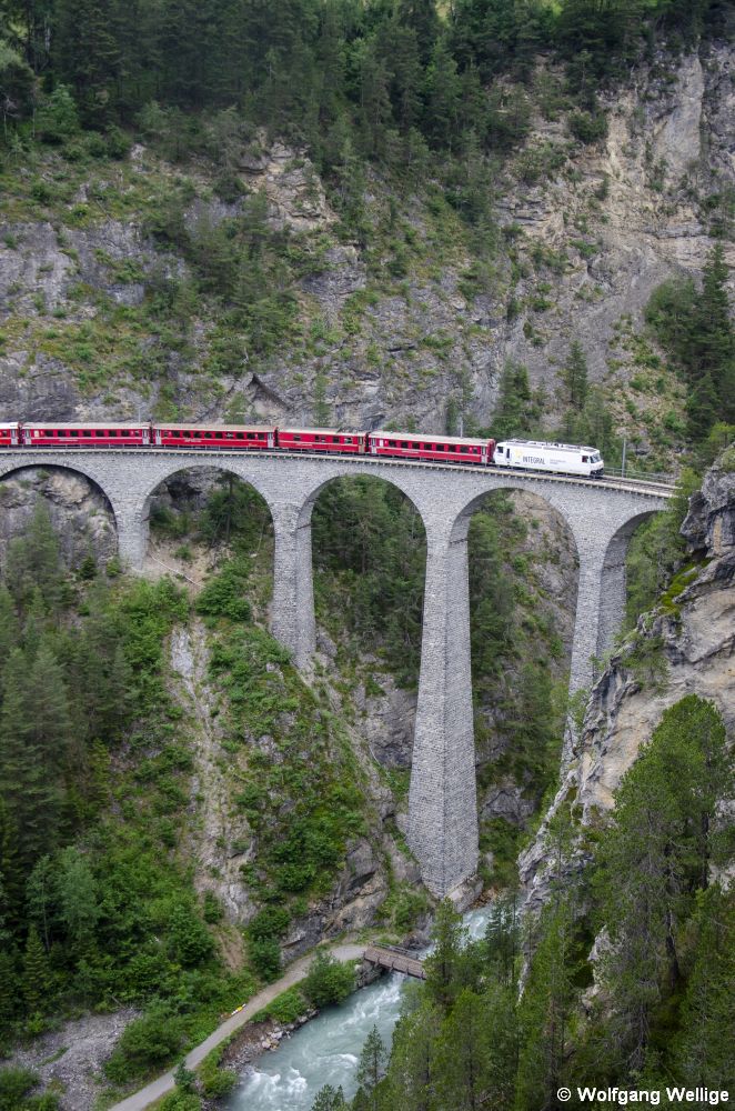 Die mit einer Werbebeklebung für die Vorsorgeeinrichtung 'Integral' versehene Lok 642 zieht am 1. Juli 2019 den IR 1141 (Chur - St. Moritz) über den oft fotografierten, 65 Meter hohen Landwasserviadukt bei Filisur.