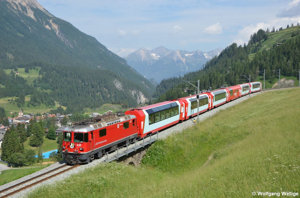 Lok 631 des Typs Ge 4/4 II der Rhätischen Bahn (RhB) rollt am 1. Juli 2019 mit dem berühmten 'Glacier-Express' am Haken talwärts auf Bergün zu